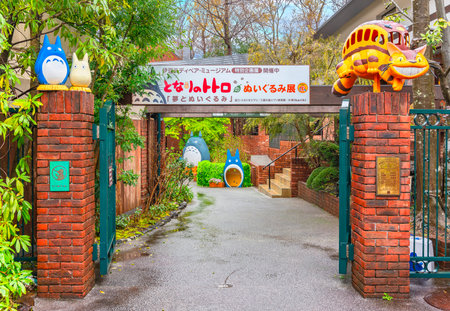 shizuoka, japan - march 26 2024: Entrance to Izu Teddy Bear Museum's Exhibition titled 'My Neighbor Totoro Plush Toy Exhibition' adorned with Totoro and Catbus figures on the gate framed with greeneryのeditorial素材
