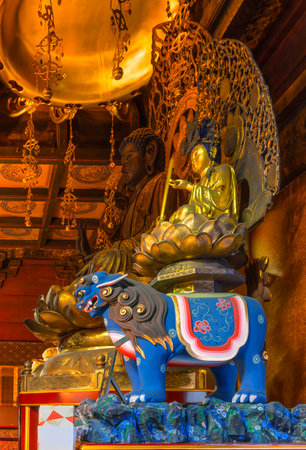 tokyo, ueno - jan 09 2024: Buddhist statues of the Japanese deity Monju on a blue tiger, symbol of intelligence and wisdom next to the bodhisattva Shaka, symbol of compassion in the Gokokuin temple.のeditorial素材