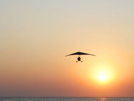 Kazantip. The hangglider in action against a red sunset at coast of the black sea