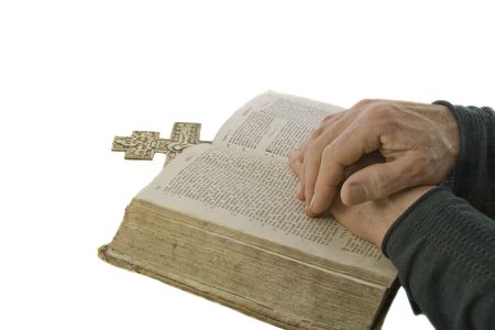 Male hands closed in prayer on an open bible isolated over white