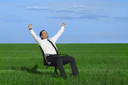 businessman take energy from nature in the meadow with dark blue skyの写真素材