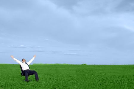 businessman take energy from nature in the meadow with dark blue skyの写真素材