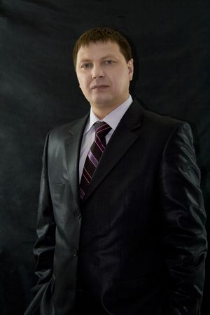 Closeup portrait of  handsome businessman over black backgroundの写真素材