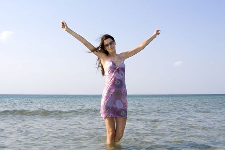 beautiful young girl in sunglasses standing in the seaの写真素材