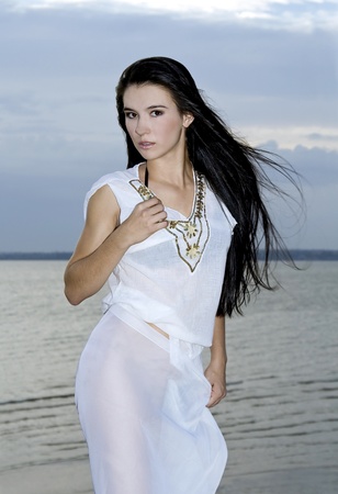 sexy brunette woman over dusk sky at sunsetの写真素材