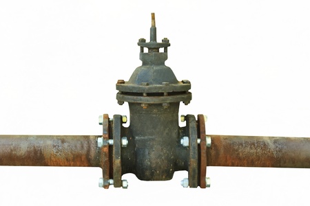 old rusty pipe with shut-off valve over green grassの写真素材