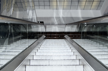 Empty escalator stairs moving up in modern office building