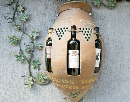 Tbilisi, Georgia - April 25, 2017: Decorative display case in the form of kvevri container with wine bottles in itのeditorial素材