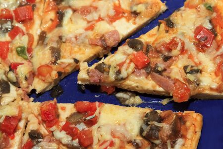 slice of hot pizza with melting cheeseの写真素材