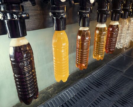 Different Craft beer pouring into a plastic bottles in the barの写真素材