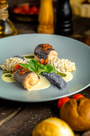 Salmon rolls stuffed with cheese and vegetables on a blue plate.の写真素材