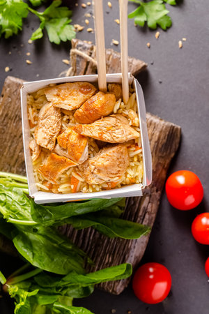 Rice with chicken and vegetables on a black background. Selective focus.の写真素材