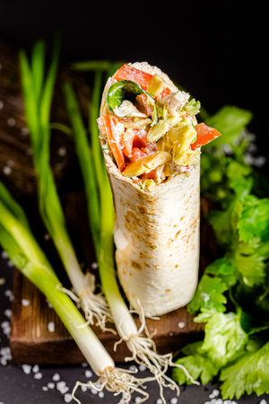 tortilla with meat and vegetables on a dark background. selective focusの写真素材