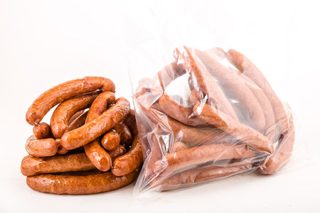 smoked sausages in plastic bag isolated on a white backgroundの写真素材