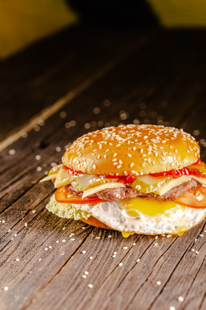 hamburger with cheese and tomato sauce on wooden table, selective focusの写真素材