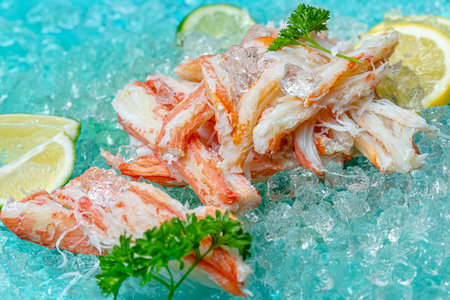 crab claws on ice with lemon and parsley, close upの写真素材