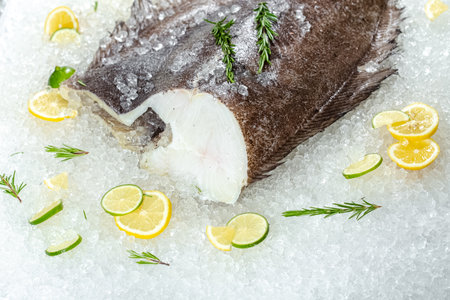 Fresh fish on ice with lemon, lime and rosemary on white backgroundの写真素材
