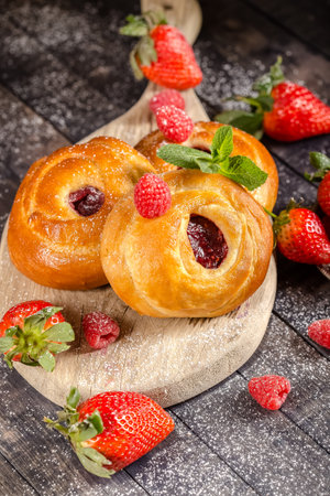 Strawberry buns with jam and fresh berries on wooden backgroundの写真素材
