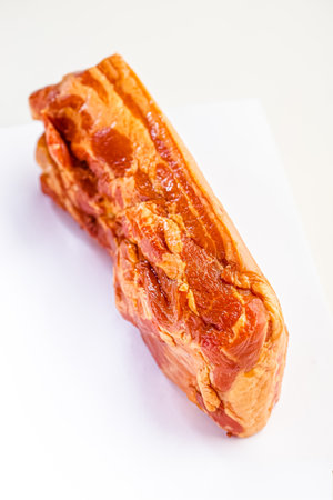 Smoked pork meat on a white cutting board on a white backgroundの写真素材