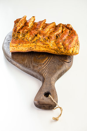 Baked loaf of bread on a wooden board on a white backgroundの写真素材