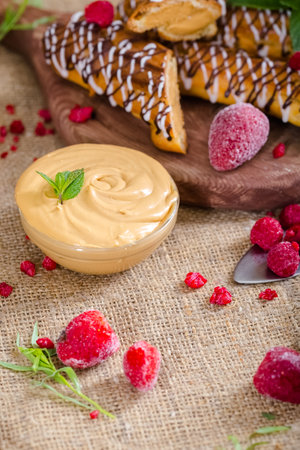 Chocolate cake with cream and raspberries on a wooden board