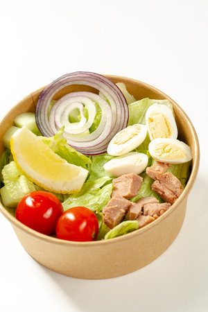 Salad with tuna, eggs, tomatoes and cucumbers in a bowlの写真素材