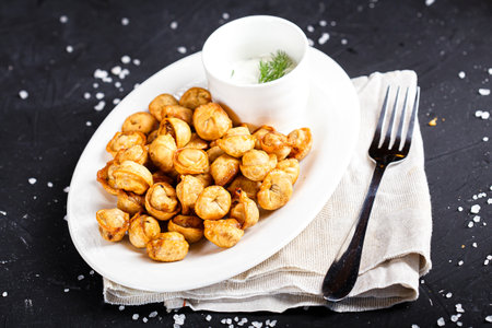 fried cashew nuts with sour cream on a black background. tinting. selective focusの写真素材