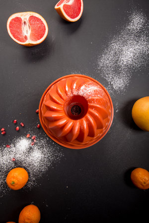 Orange cake on a black background with citrus fruits. Top view.の写真素材