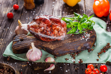 smoked meat with spices and vegetables on a wooden rustic backgroundの写真素材
