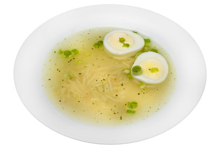 Chicken soup with egg and green peas isolated on a white background.の写真素材