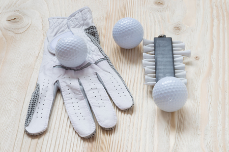 glove and golf balls on a light surfaceの写真素材
