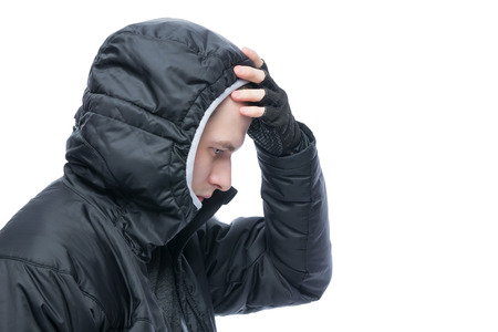 a man in a black jacket hood removes the handの写真素材