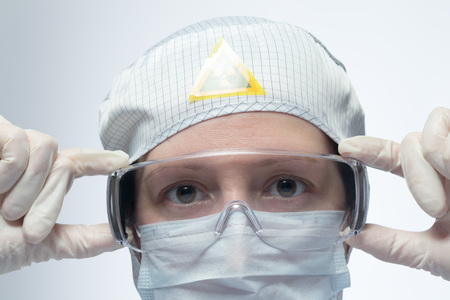 Scientist putting on protective eyewearの写真素材