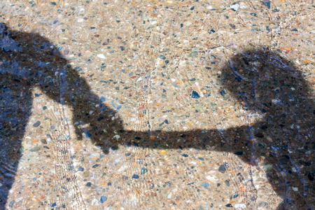 shadow in the water, dad and daughter joined handsの写真素材