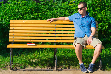 young man sitting on the benchの写真素材