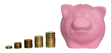 a lot of piles of coins of varying heights and pink pigの写真素材