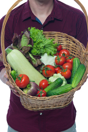 beautiful basket of vegetables in the hands of the farmerの写真素材