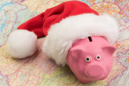 piggy bank in a red cap on the mapの写真素材