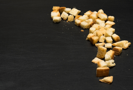 golden slices of white bread lying on a black tableの写真素材