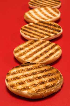 fried pieces of bread in a row on a red tableの写真素材