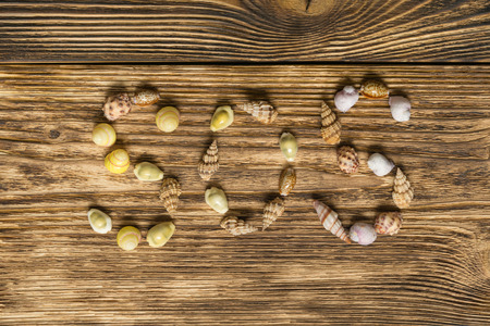 seashells laid out inscription SOS on the background of the boardの写真素材