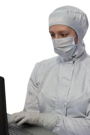 Scientist in protective suit works with a computer on a white backgroundの写真素材
