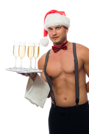 waiter in a cap of Santa Claus with a beautiful body brought champagneの写真素材