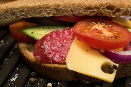 sandwich with sausage and vegetables on grill closeupの写真素材