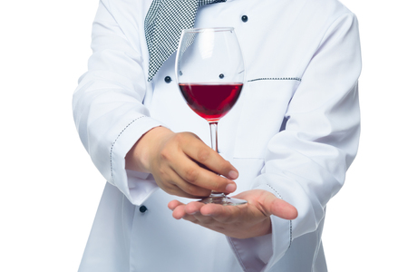 cook holds in the palm of a glass of red wine on a white backgroundの写真素材