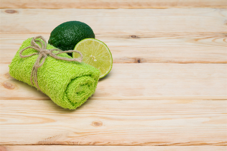 green towel,  lime on a wooden tableの写真素材