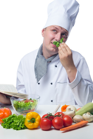 chef with recipe book thinks about cooking vegetablesの写真素材
