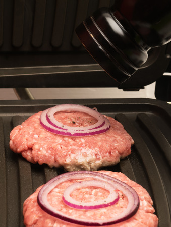 meat on the stove rattling off the the seasoning out of the millの写真素材