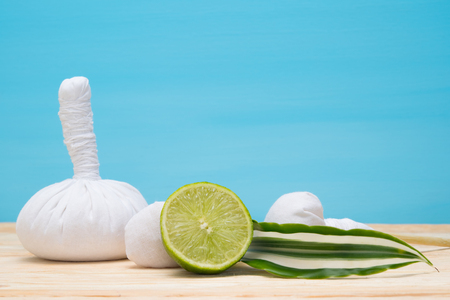 bags for a massage on a table and lime on a blue backgroundの写真素材