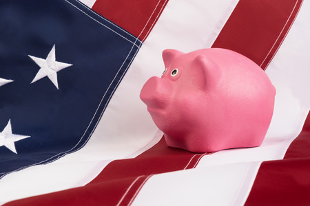 pink piggy bank for  money standing on a US flagの写真素材